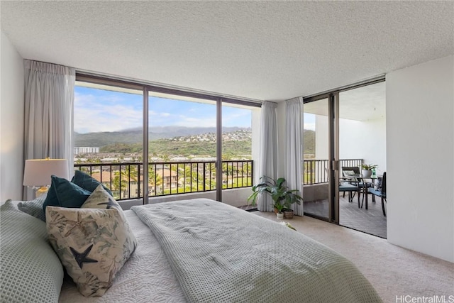 bedroom featuring a textured ceiling, access to outside, and carpet flooring