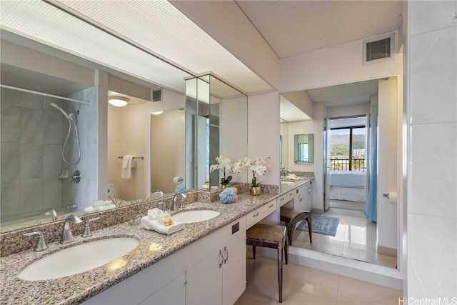 bathroom featuring double vanity, tile patterned flooring, visible vents, and a sink