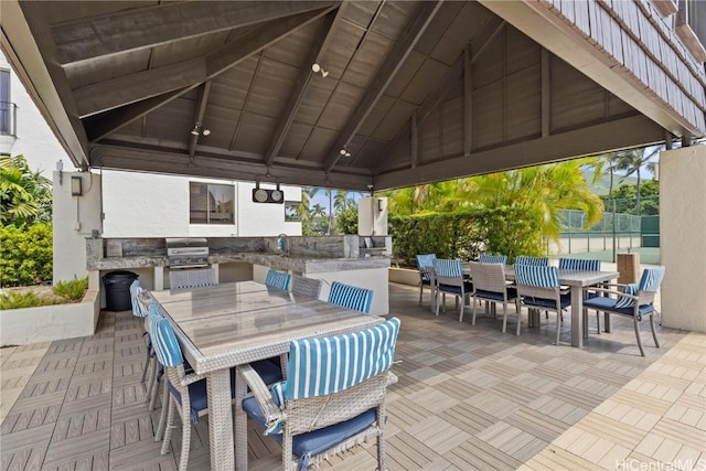 view of patio / terrace featuring an outdoor kitchen, fence, outdoor dining area, and a gazebo