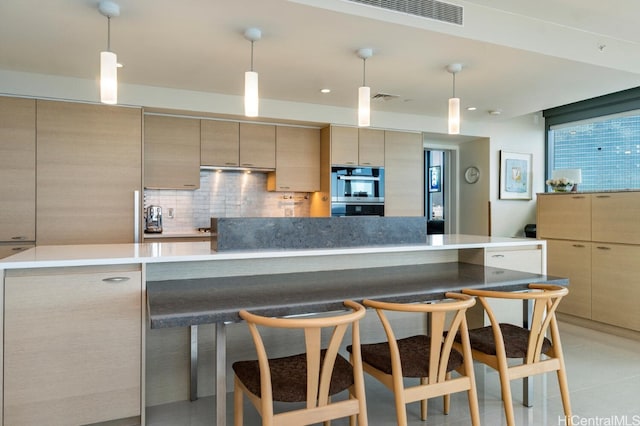 kitchen with pendant lighting, a spacious island, tasteful backsplash, visible vents, and double oven