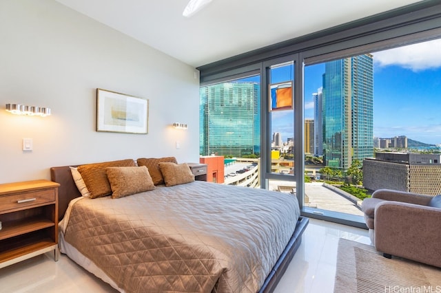 tiled bedroom with expansive windows, a city view, and access to exterior