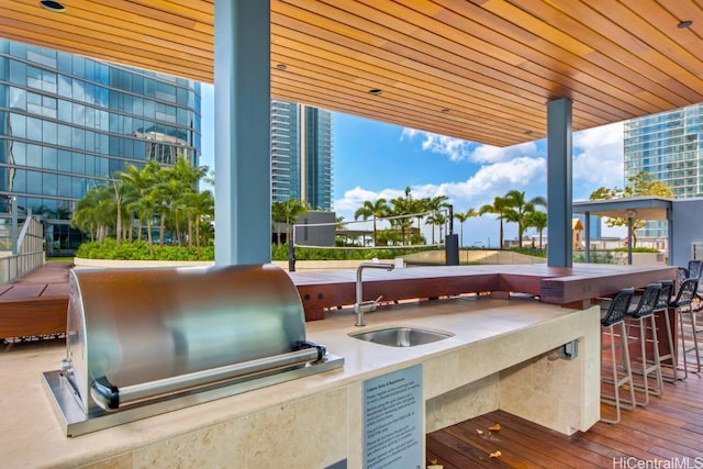 view of patio / terrace with outdoor wet bar, a sink, exterior kitchen, and area for grilling