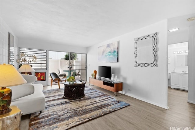 living area featuring baseboards and wood finished floors