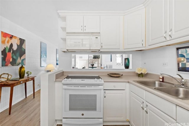 kitchen featuring white appliances, light wood-style flooring, white cabinetry, and a sink