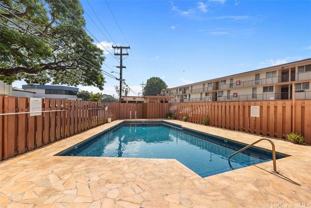 pool with a fenced backyard and a patio