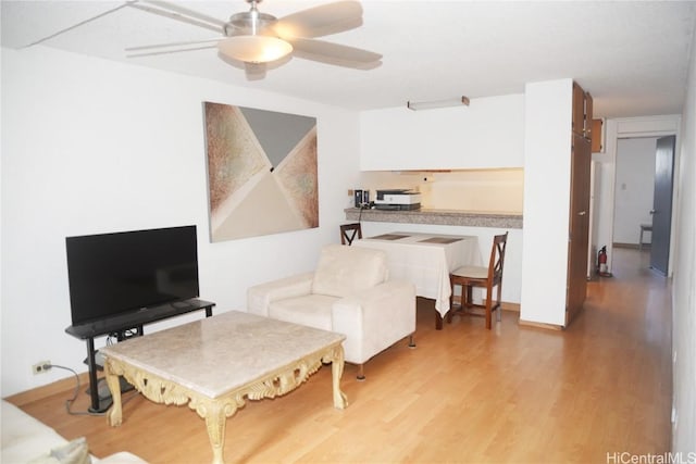 living room with a ceiling fan and wood finished floors