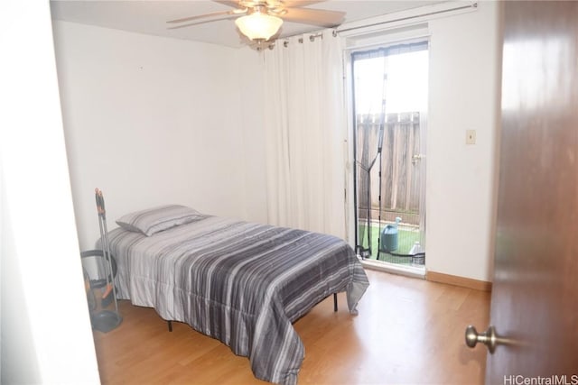 bedroom with access to outside, wood finished floors, a ceiling fan, and baseboards