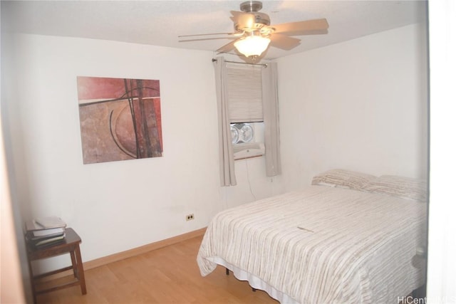 bedroom with ceiling fan, baseboards, and wood finished floors