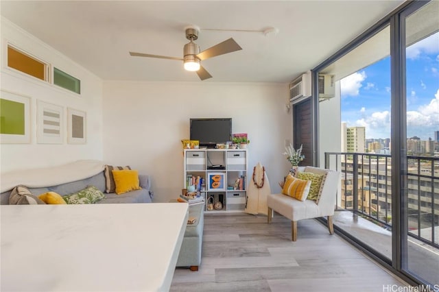 interior space featuring a ceiling fan, access to outside, expansive windows, wood finished floors, and a wall unit AC