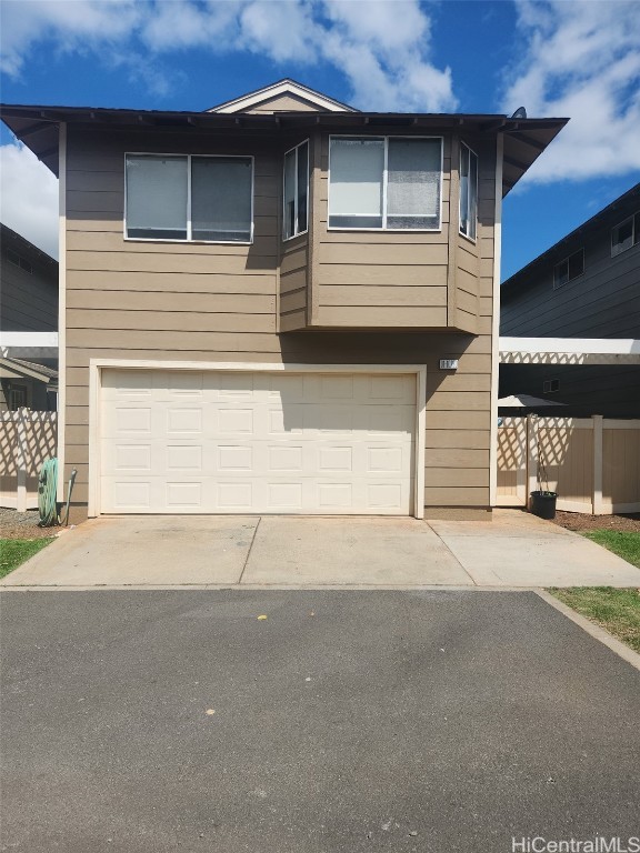 view of front of property with driveway, an attached garage, and fence