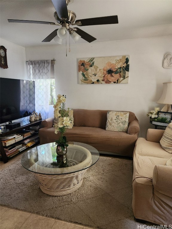 tiled living area with ceiling fan