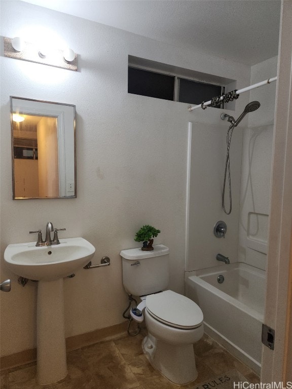 bathroom featuring shower / washtub combination, baseboards, a sink, and toilet