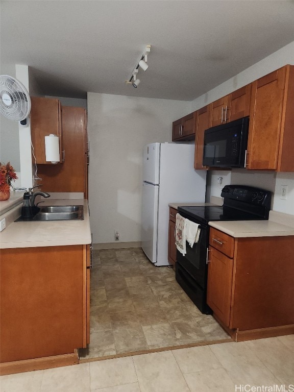 kitchen with brown cabinetry, light countertops, a sink, and black appliances