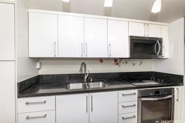 kitchen featuring stainless steel appliances, white cabinets, and a sink