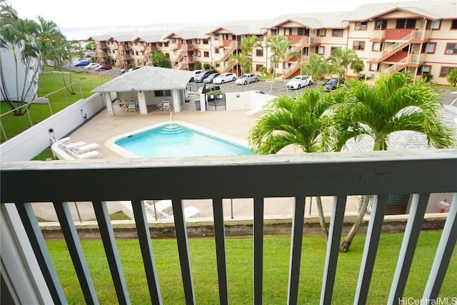 community pool featuring a residential view, a patio, and a yard