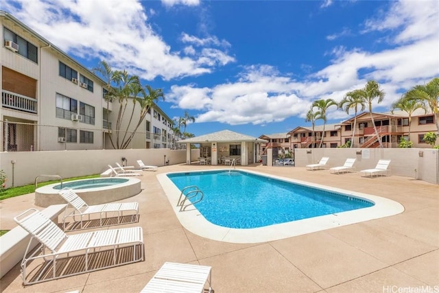 pool featuring a patio area, fence, and a hot tub