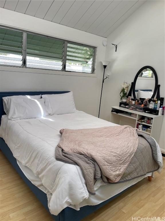 bedroom featuring vaulted ceiling, wooden ceiling, and wood finished floors