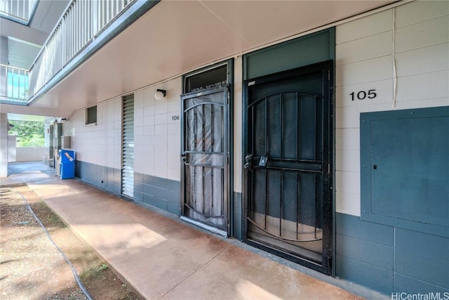 property entrance featuring concrete block siding and electric panel