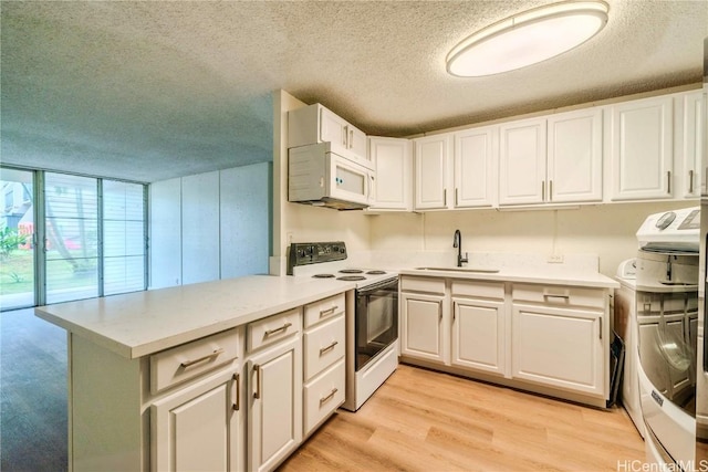 kitchen featuring light wood-type flooring, white microwave, a sink, washer / dryer, and range with electric cooktop