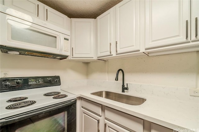 kitchen with electric range, white microwave, a sink, and white cabinetry