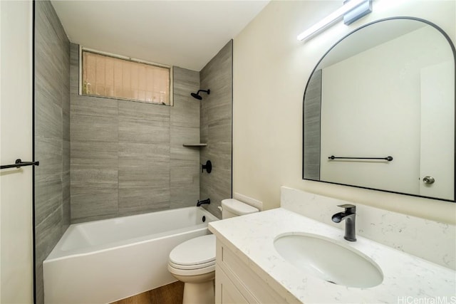 full bath featuring wood finished floors, shower / washtub combination, vanity, and toilet