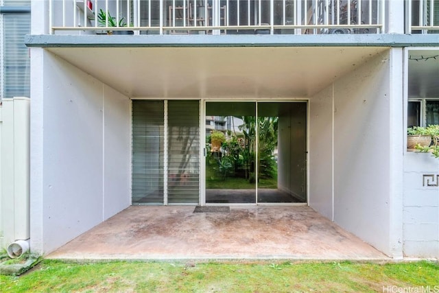 doorway to property with a balcony and stucco siding