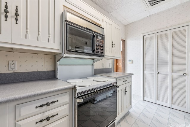 kitchen featuring black microwave, visible vents, marble finish floor, white range with electric cooktop, and wallpapered walls