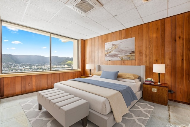 bedroom with visible vents, wood walls, baseboards, and a mountain view