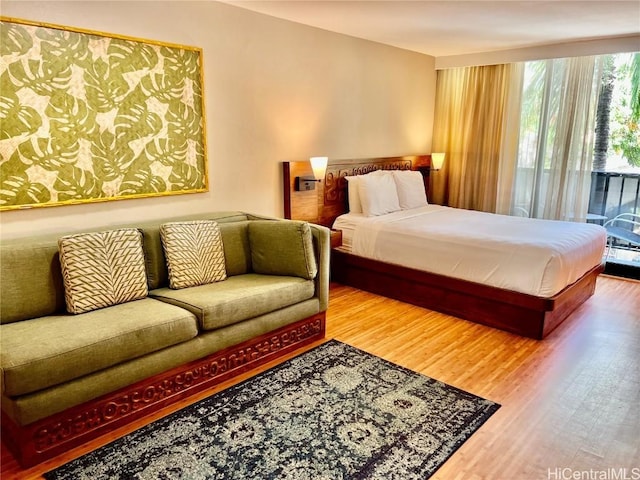 bedroom featuring wood finished floors and access to exterior