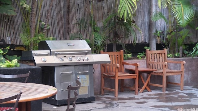 view of patio / terrace with an outdoor kitchen, fence, and a grill