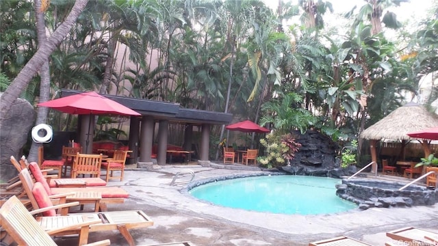 outdoor pool featuring outdoor dining space and a patio area