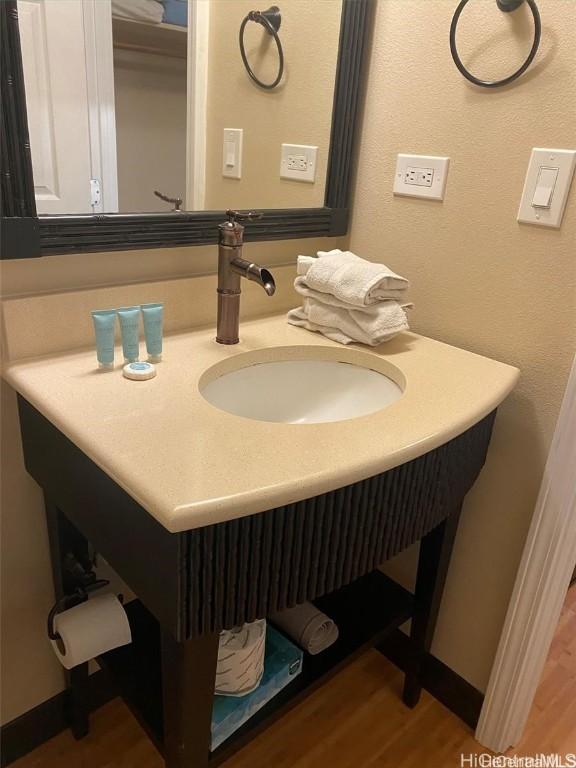 bathroom featuring wood finished floors, vanity, and baseboards