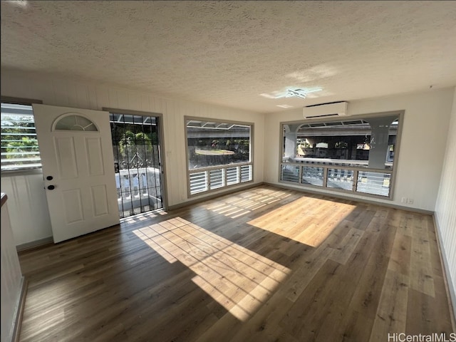 4509 Luaole St, Honolulu, HI 96818 - interior space featuring a textured ceiling, a wall mounted AC, and wood finished floors