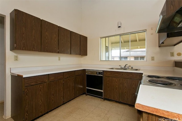 kitchen with under cabinet range hood, light floors, a sink, and light countertops