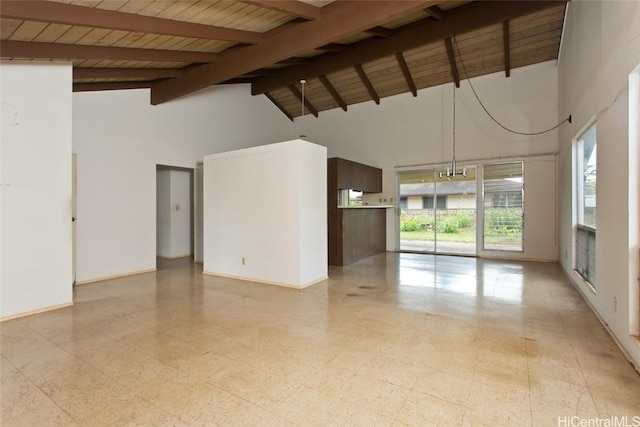 empty room with baseboards, wooden ceiling, light floors, high vaulted ceiling, and beam ceiling