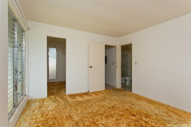 unfurnished bedroom with a textured ceiling and carpet flooring