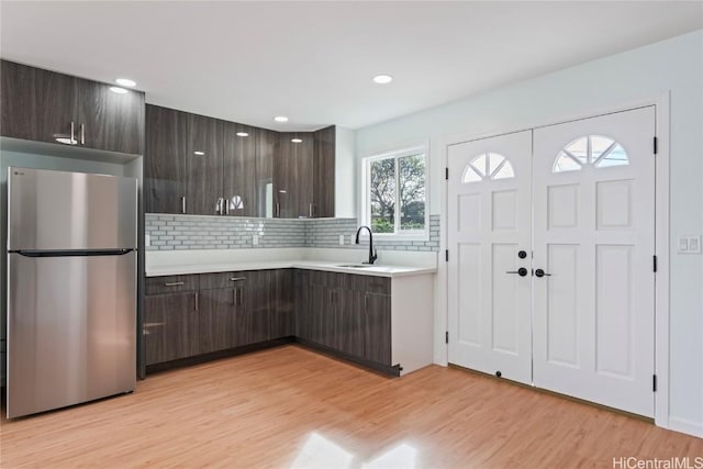 kitchen featuring freestanding refrigerator, light countertops, and dark brown cabinetry