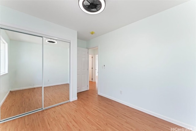 unfurnished bedroom featuring a closet, light wood-type flooring, visible vents, and baseboards