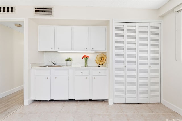 2440 Kuhio Ave Unit 1101, Honolulu, HI 96815 - kitchen with light countertops, white cabinets, and light tile patterned flooring