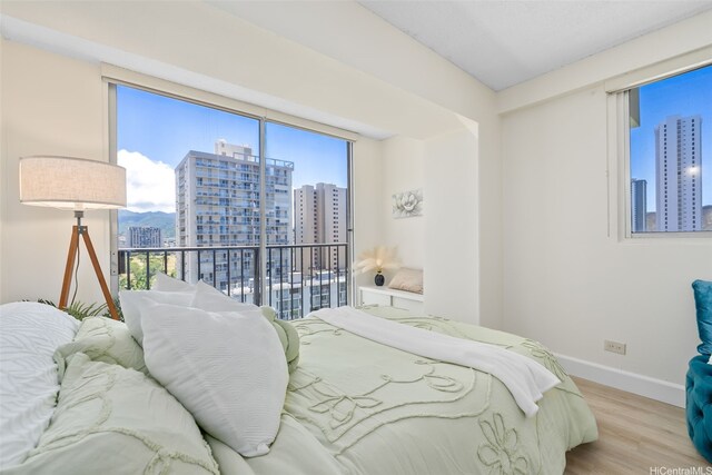 2440 Kuhio Ave Unit 1101, Honolulu, HI 96815 - bedroom with a city view, wood finished floors, and multiple windows