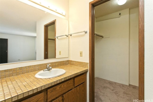 bathroom featuring a walk in closet and vanity