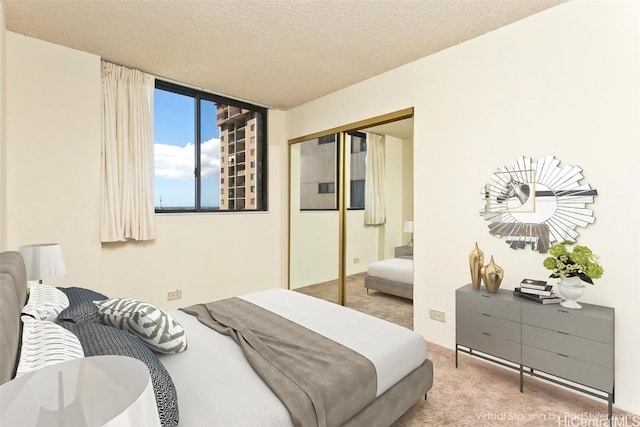 bedroom featuring carpet, a closet, and a textured ceiling