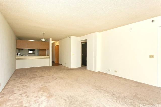 unfurnished living room featuring carpet flooring and a textured ceiling