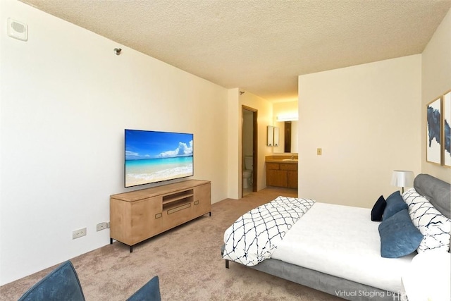 carpeted bedroom with a textured ceiling and ensuite bathroom