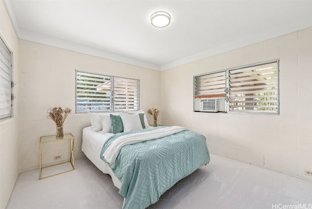 bedroom with concrete block wall and cooling unit