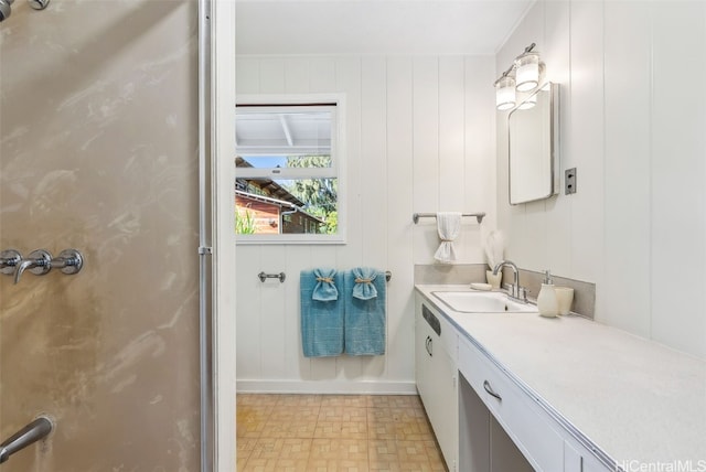 full bath featuring a shower with door, baseboards, and vanity