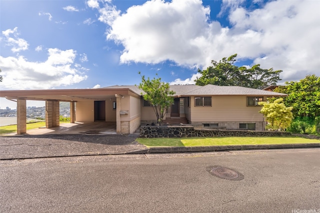 view of front of property with a front yard, a carport, and aphalt driveway