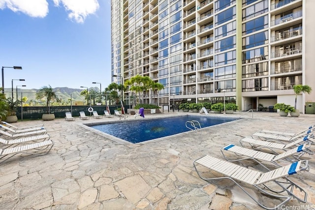 pool with a patio and fence