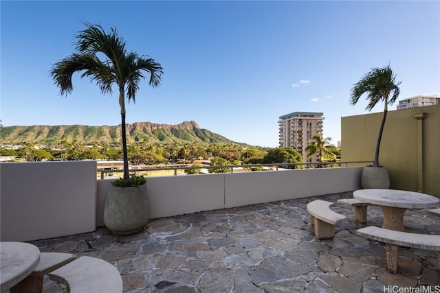 view of patio featuring a mountain view and a balcony