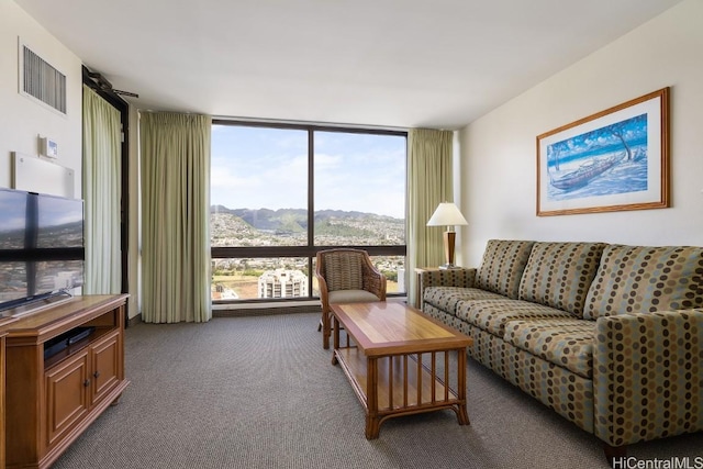 carpeted living area featuring visible vents, a mountain view, and expansive windows